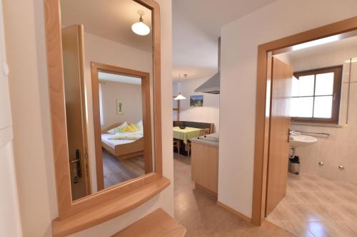 Appartements Lenzenhof في بارشينيس: حمام مع مرآة وغرفة مع سرير