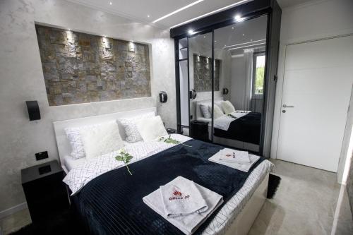 a bedroom with a large bed and a mirror at APARTMAN DELUX 20 in Subotica