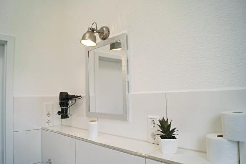 a white bathroom with a mirror and a sink at Charmante & Gemütliche Wohnung in Solingen