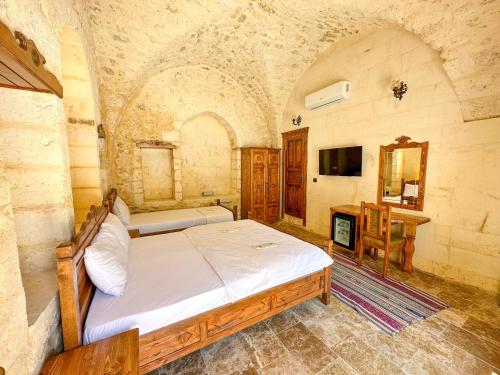 a bedroom with a bed and a desk and a television at PALMYRA BOUTIQUE HOTEL in Sanlıurfa