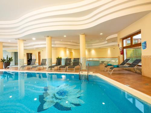a swimming pool in a hotel with chairs and tables at Active Hotel Paradiso in Peschiera del Garda
