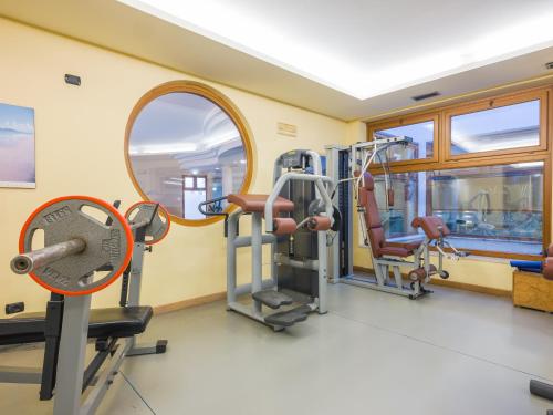 a gym with tread machines and a mirror at Active Hotel Paradiso in Peschiera del Garda