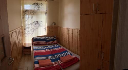 a small room with a bed and a window at Mediterán Fedett Medencés Apartmanház in Szántód