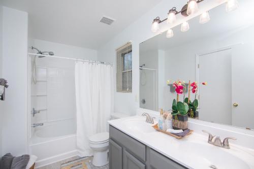 La salle de bains est pourvue d'un lavabo, de toilettes et d'un miroir. dans l'établissement Stylish Home Phoenix - Low Rates NOW!, à Phoenix