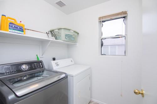 a kitchen with a washing machine and a window at Stylish Home Phoenix - Low Rates NOW! in Phoenix