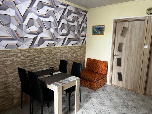 a dining room with a table and a chair at Mediterán Fedett Medencés Apartmanház in Szántód