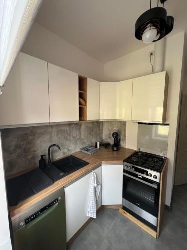 uma cozinha com armários brancos e um forno com placa de fogão em Cozy room between Kazimierz and Stare Miasto em Cracóvia