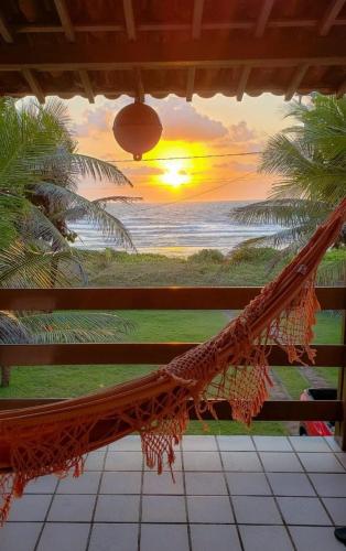a hammock in a room with a view of the ocean at casa de praia a beira mar in Campina