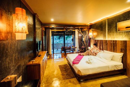 a woman laying on a bed in a room at Andalay Beach Resort Koh Libong in Ko Libong
