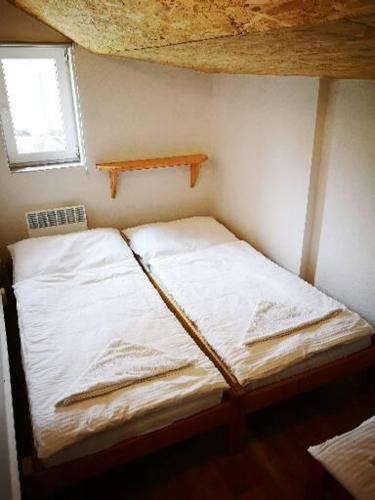 a room with two beds in a room with a window at Chata u jeskyně Mladeč in Bílá Lhota