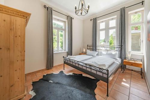a bedroom with a bed and a chandelier at Villa Emma in Bad Schandau