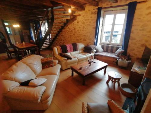 a living room with couches and a coffee table at Le Temps Serein in Vabre-Tizac
