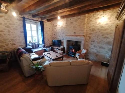 a living room with two couches and a fireplace at Le Temps Serein in Vabre-Tizac