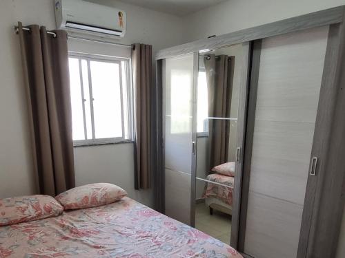 um quarto com uma cama e uma porta de vidro deslizante em Apartamento Vila Aconchego Vermelho em Salvador