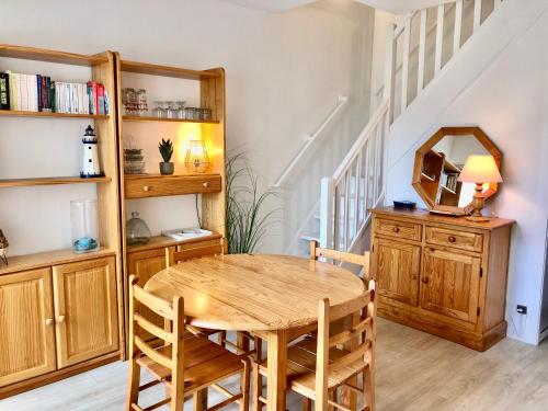 une salle à manger avec une table et des chaises en bois dans l'établissement SUNSET 3 pieces centre Moulleau 50 m de la plage, à Arcachon