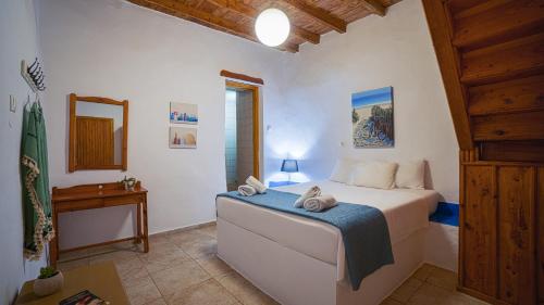 a bedroom with a bed with a blue blanket on it at Villa Niki in Loutro