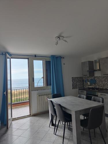 a dining room with a table and a view of the ocean at Casa Josè Suite Mare in Palermo