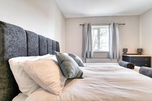 um quarto com uma cama grande com almofadas em Guest Homes - Birches Barn em Wolverhampton