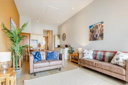 a living room with two couches and a kitchen at Woodside Apartments in St. Andrews