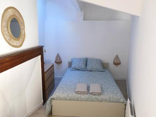 une petite chambre avec un lit et un miroir dans l'établissement Elégant T2 Proche Cathédrale Centre Historique, à Albi