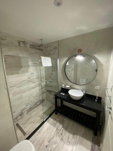 a bathroom with a sink and a mirror at Glo apart hotel in Cañuelas