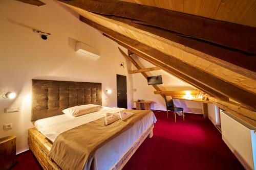 a bedroom with a large bed in a attic at Hotel Ryzlink in Mikulov