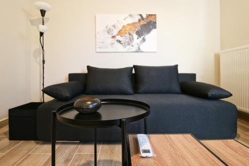 a living room with a blue couch and a table at Aellō luxury apartments in Markopoulo
