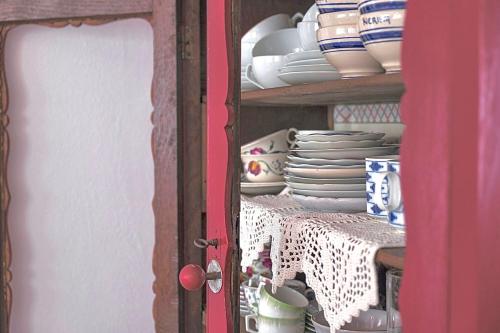 a cabinet filled with plates and cups and dishes at Casa Angiolina - Holidays in Morcote