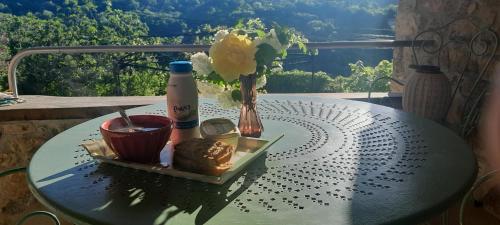 une table avec une assiette de nourriture et un vase avec des fleurs dans l'établissement gite typique ardechois sous le figuier, à Vals-les-Bains