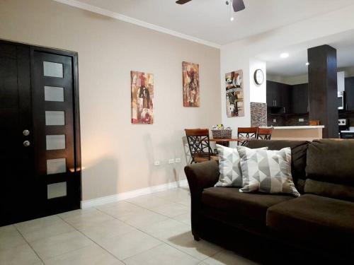 sala de estar con sofá marrón y cocina en Choose To Be Happy at Brompton Estates - One and Two Bedroom with Pool, en Kingston