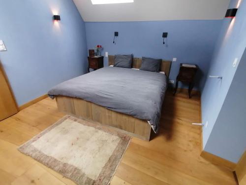 Le Temps Serein في Vabre-Tizac: غرفة نوم بسرير كبير في غرفة زرقاء