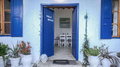 a blue door to a house with potted plants at Villa Niki in Loutro