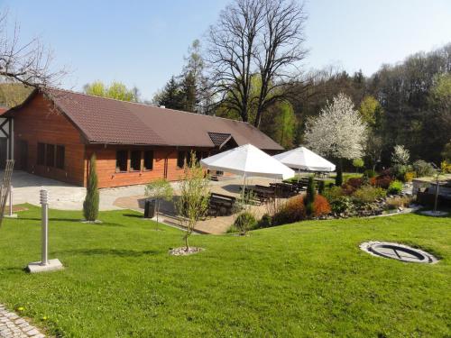 a building with two white umbrellas in a yard at Chata nad Sztolnią in Bystrzyca Górna