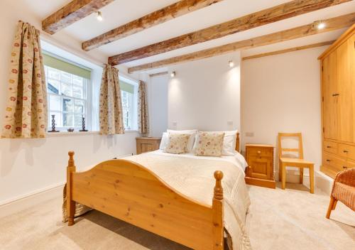 a bedroom with a wooden bed and a window at Storm Cottage in Robin Hood's Bay
