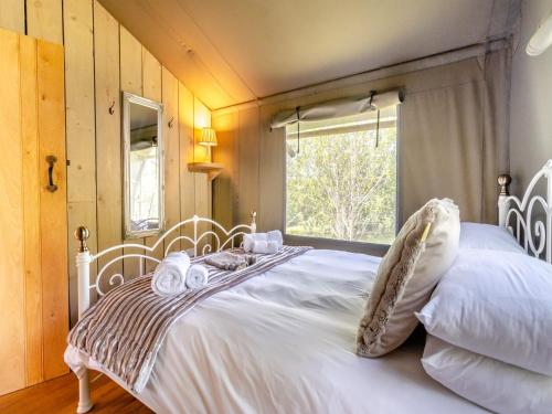 Schlafzimmer mit einem großen weißen Bett und einem Fenster in der Unterkunft Bluebell - Uk43602 in Llangyniew