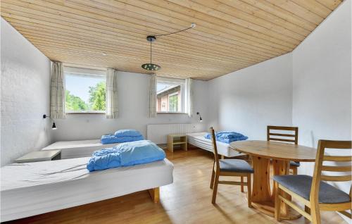 ロンストラップにあるNice Home In Lkken With 13 Bedrooms, Sauna And Wifiのベッドルーム1室(ベッド2台、テーブル、椅子付)