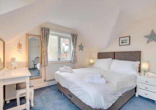 - une chambre avec un grand lit blanc et un bureau dans l'établissement Starlight Cottage, à Whitby