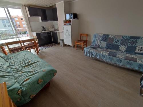 un salon avec un canapé et une cuisine dans l'établissement LE COLISEE Joli studio cabine Mt St Martin proche port Cap d'Agde, au Cap d'Agde