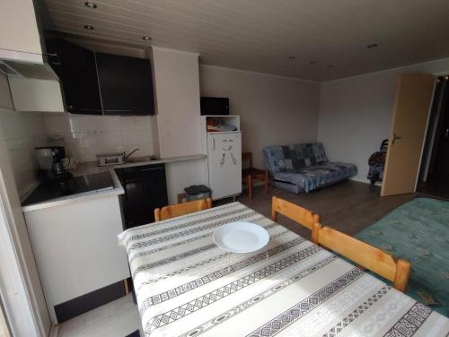 une cuisine et une salle à manger avec une table dans une pièce dans l'établissement LE COLISEE Joli studio cabine Mt St Martin proche port Cap d'Agde, au Cap d'Agde