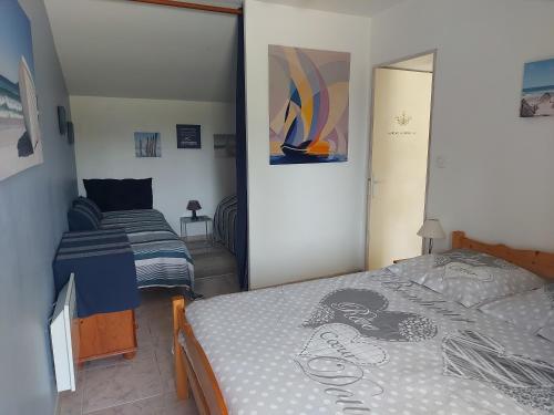 een kleine slaapkamer met een bed en een klein bed bij MOULIN DE MAUZAC - Gîte Cap Océan in Saint-Just