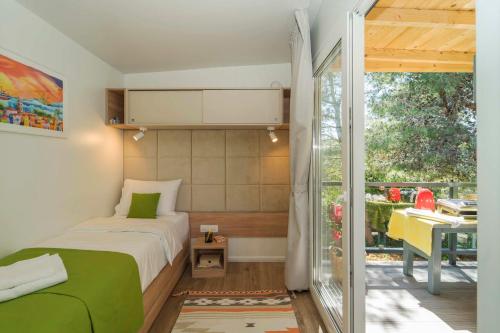 a bedroom with a bed and a desk and a window at Holiday Home Artina 1 in Lovište