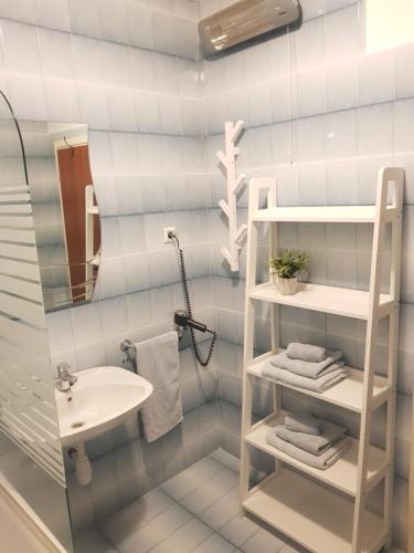 baño con lavabo y estante blanco en Apartments Huljić, en Hvar