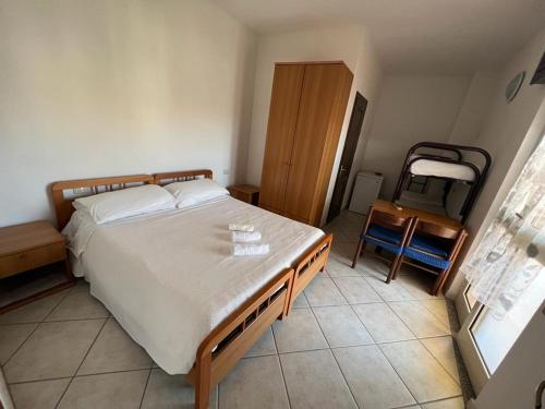 a bedroom with a bed and a table and a chair at Silver rooms in La Caletta