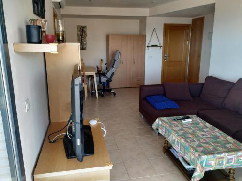 a living room with a couch and a flat screen tv at Frontal Las Terrazas 1 en Marina d`Or in Oropesa del Mar