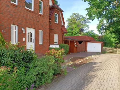 a brick house with a driveway in front of it at Moderne Ferienwohnung mit Kamin u Garten im EG 100qm Nähe Weser und Golfplatz in Achim