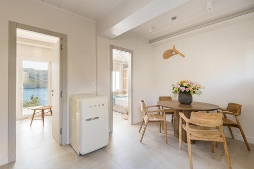 a kitchen and dining room with a table and a refrigerator at Etesians Suites & Villas in Super Paradise Beach