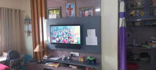 een woonkamer met een televisie op een plank bij Assan Place in Bhubaneshwar