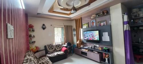 een woonkamer met een bank en een tv bij Assan Place in Bhubaneshwar
