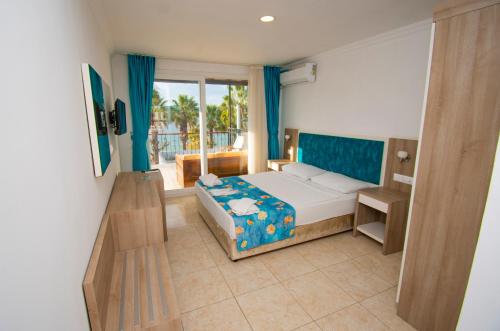 a bedroom with a bed and a balcony at Sami Beach Hotel- All Inclusive in Gümbet