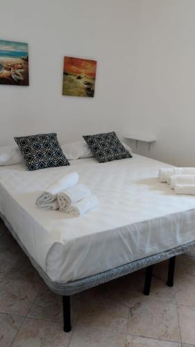 duże łóżko z białą pościelą i ręcznikami w obiekcie Freshwater pirates gaeta vecchia w mieście Gaeta